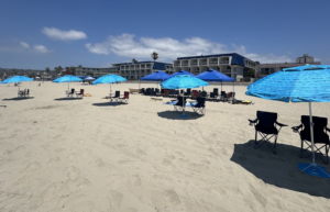 Corporate beach event with canopies, seating, tables, and games prepared for a company gathering in San Diego.