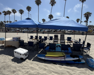 Beach canopy with chairs, towels, cooler, and beach gear ready for a relaxing day in Mission Bay.