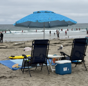 Beach canopy and umbrella with chairs and towels set up at La Jolla Shores in San Diego.